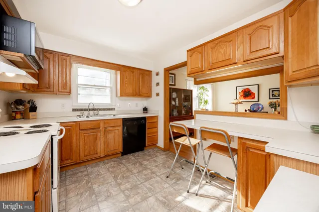 a kitchen with stainless steel appliances granite countertop a stove a sink dishwasher and a refrigerator with wooden cabinets