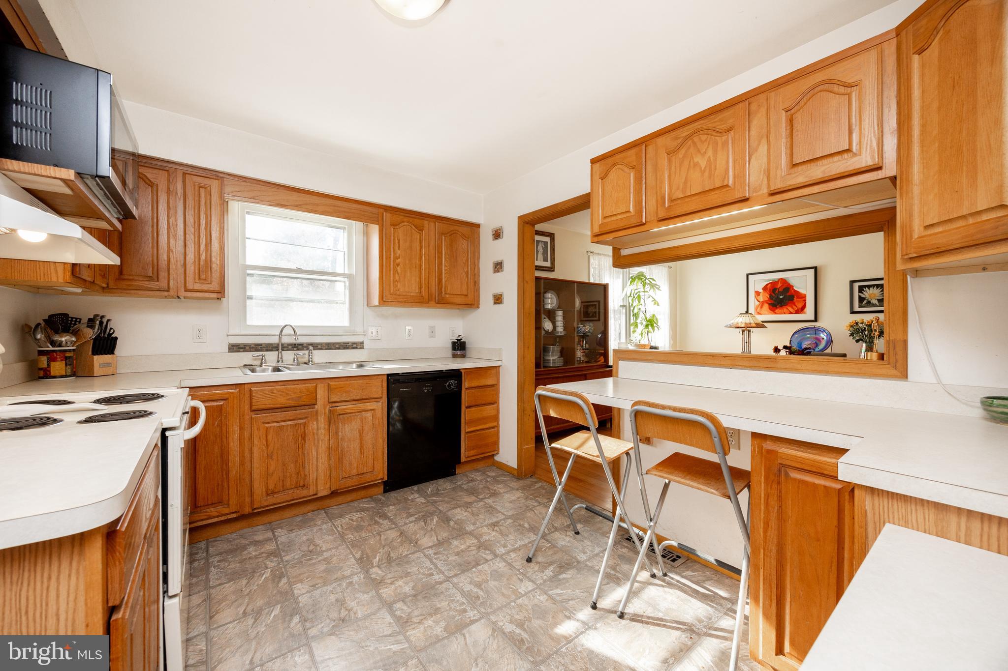 4455 Bethel Road Upper Chichester, PA 19061 - Photo 9 of 27 a kitchen with stainless steel appliances granite countertop a stove a sink dishwasher and a refrigerator with wooden cabinets