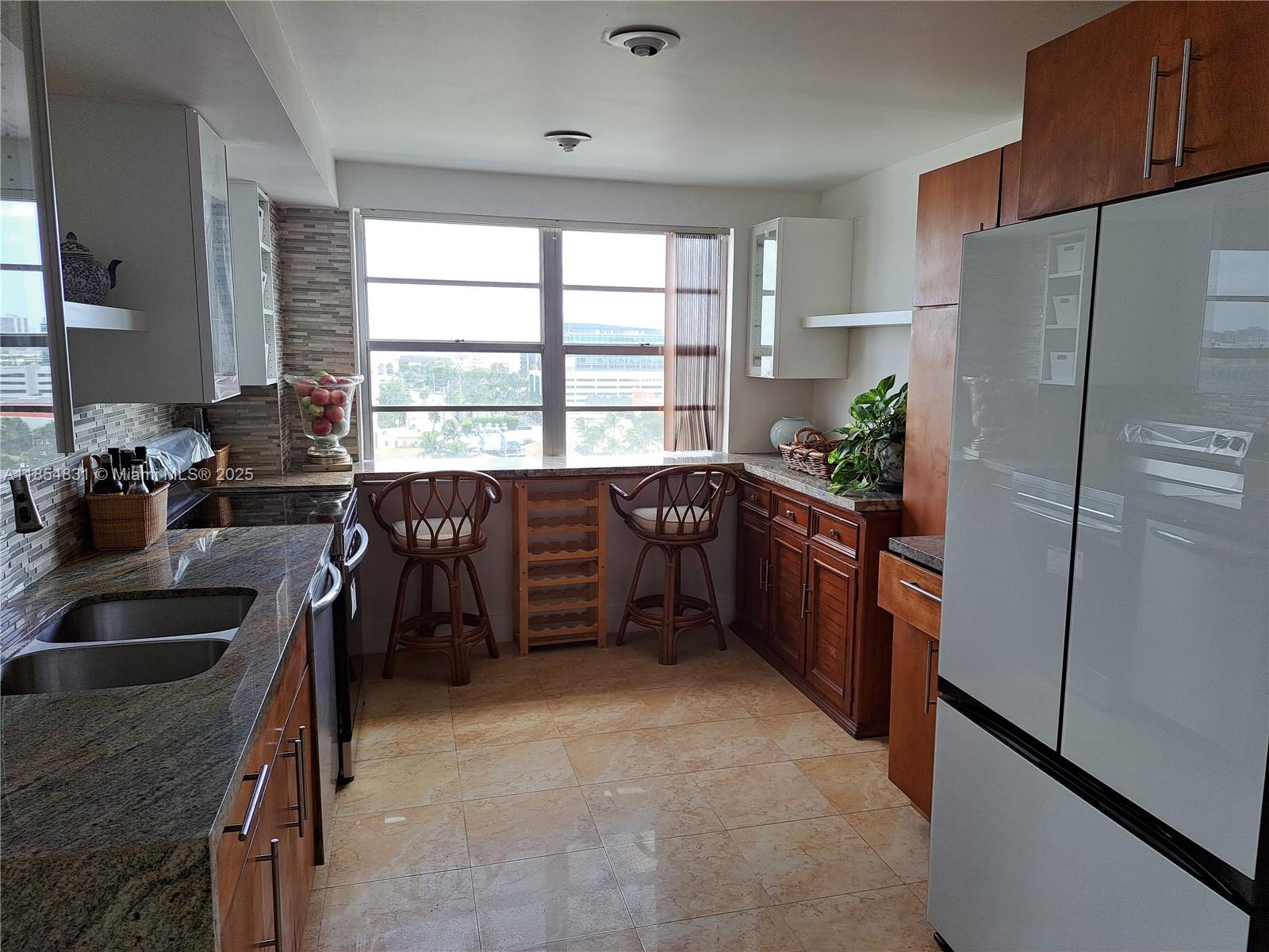 2801 Northeast 183rd Street, Unit 1401W Aventura, FL 33160 - Photo 20 of 26 a kitchen with stainless steel appliances a sink a counter and a refrigerator