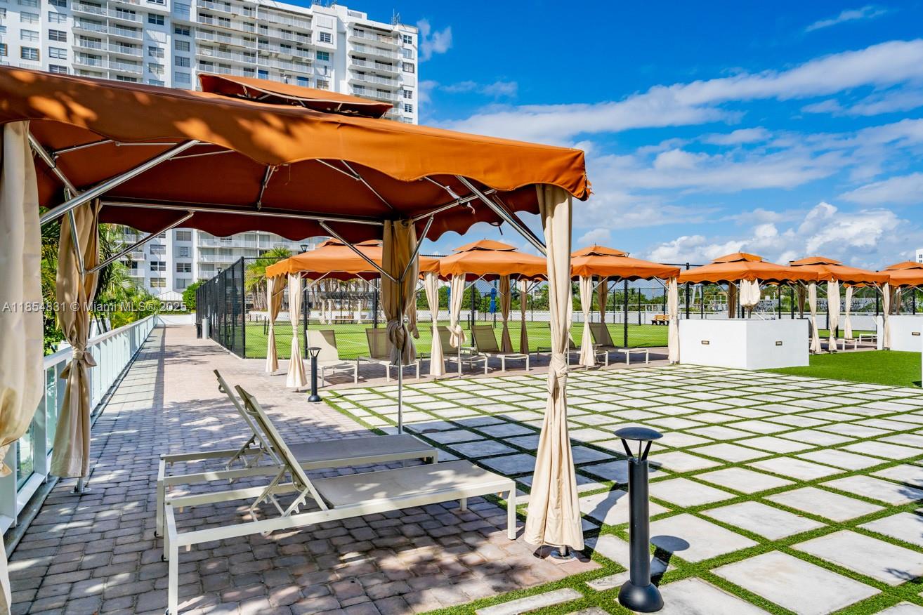 2801 Northeast 183rd Street, Unit 1401W Aventura, FL 33160 - Photo 2 of 26 a view of a patio with a table and chairs under an umbrella