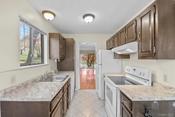 a kitchen with a stove a sink a refrigerator and a wooden cabinets
