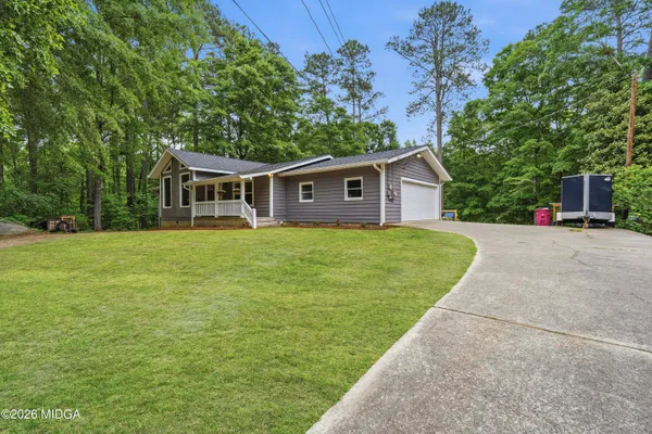 a view of a house with a yard and sitting area