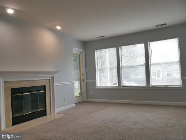 an empty room with a fireplace and windows