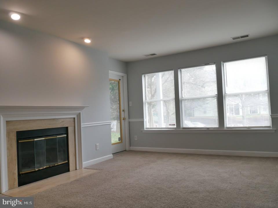 13701 Modrad Way, Unit 9C12 Silver Spring, MD 20904 - Photo 6 of 12 an empty room with a fireplace and windows