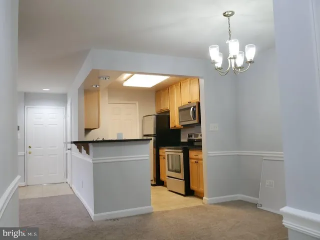 a kitchen with stainless steel appliances granite countertop a sink and a refrigerator
