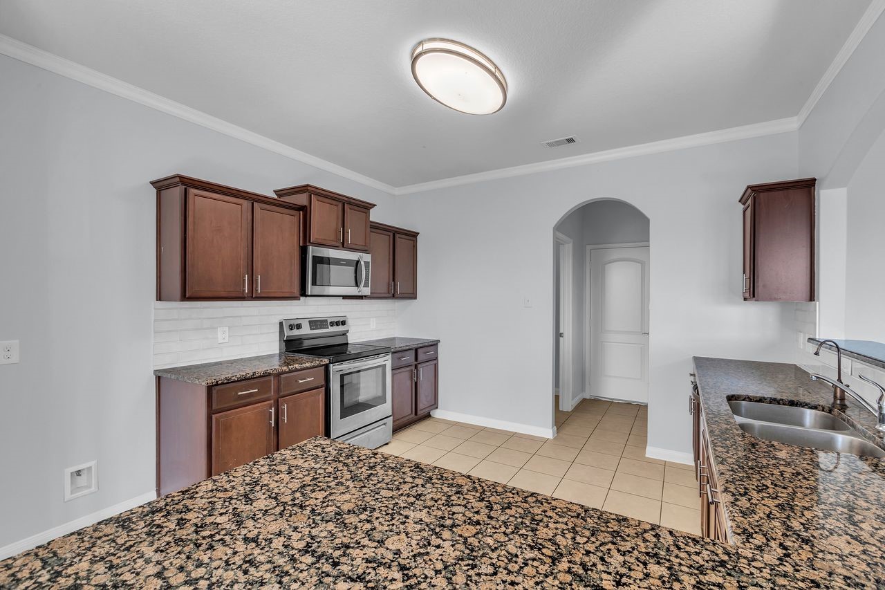 22703 Threefold Ridge Drive Hockley, TX 77447 - Photo 18 of 36 a kitchen with a sink cabinets and window