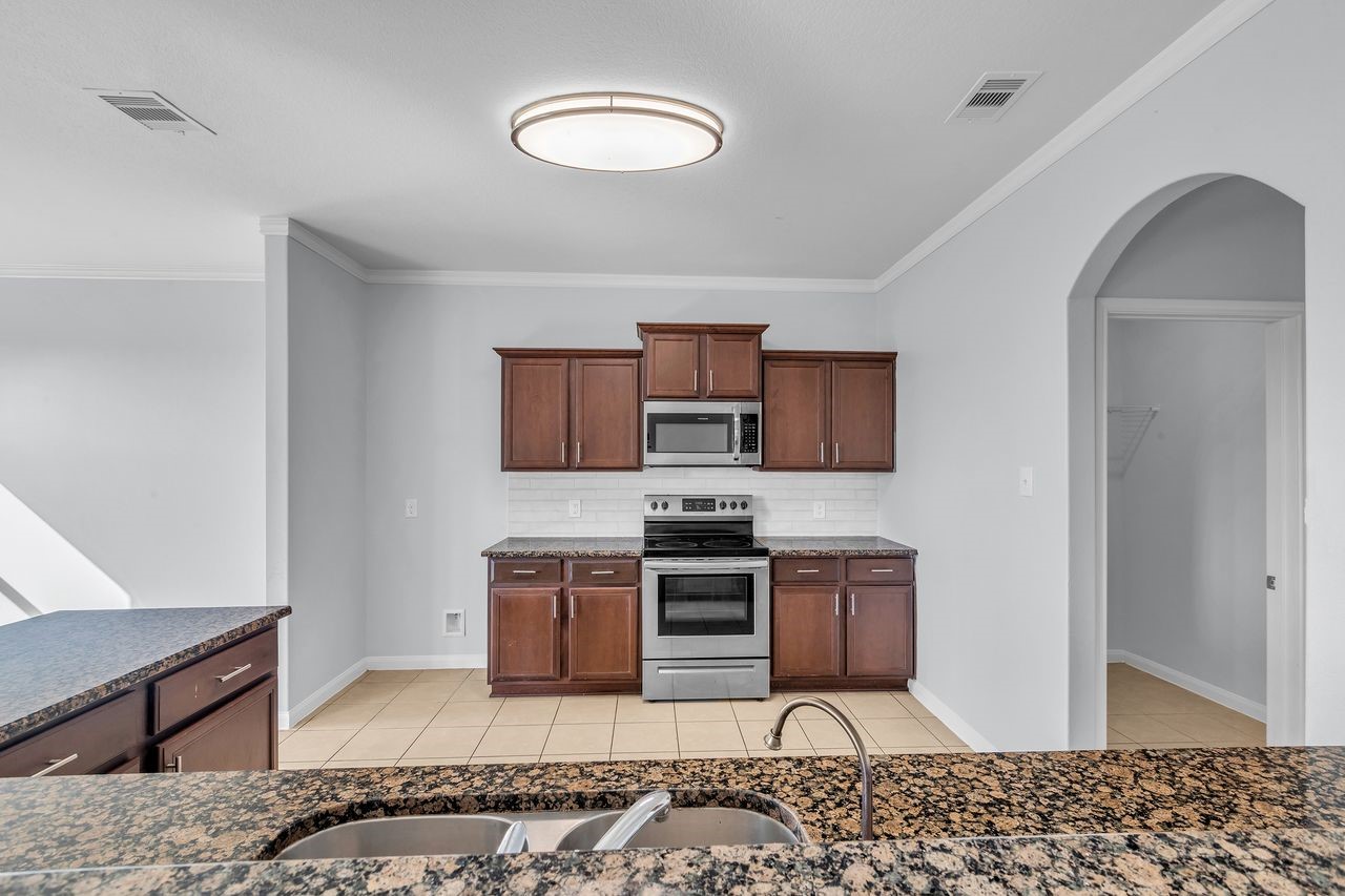 22703 Threefold Ridge Drive Hockley, TX 77447 - Photo 23 of 36 a kitchen with stainless steel appliances granite countertop a stove a sink and a microwave