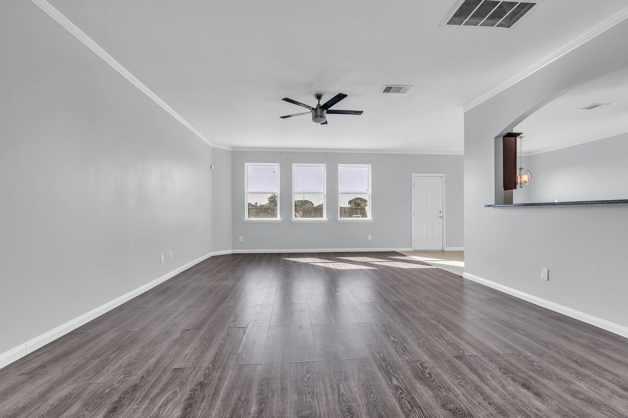 22703 Threefold Ridge Drive Hockley, TX 77447 - Photo 6 of 36 an empty room with wooden floor chandelier fan and windows