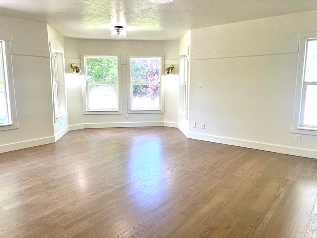 812 East Bates Cyn Road Tooele, UT 84074 - Photo 34 of 144 Spacious room featuring wood-finish flooring, white trim, and multiple windows