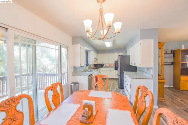 a dining room with furniture a chandelier and wooden floor