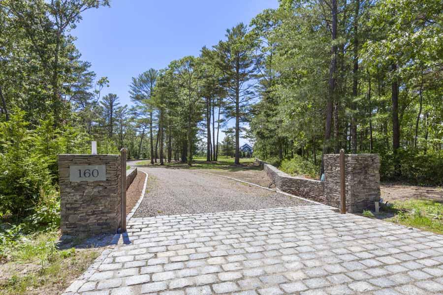 160 Peppercorn Lane Cotuit, MA 02635 - Photo 4 of 43 a view of a backyard with large trees and wooden fence