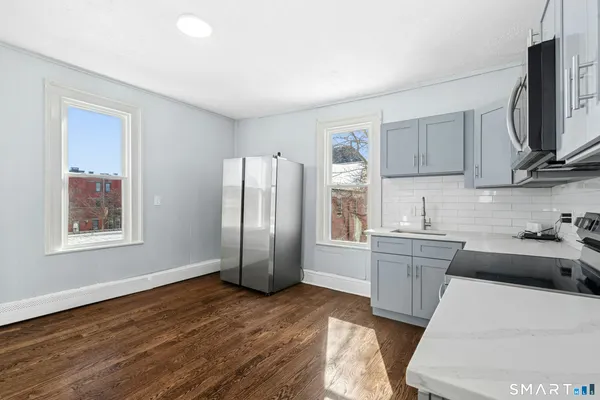 a kitchen with stainless steel appliances granite countertop a refrigerator sink and microwave