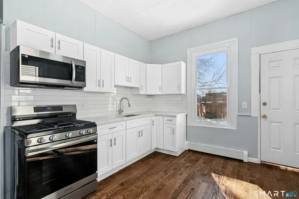 a kitchen with stainless steel appliances a stove microwave and sink