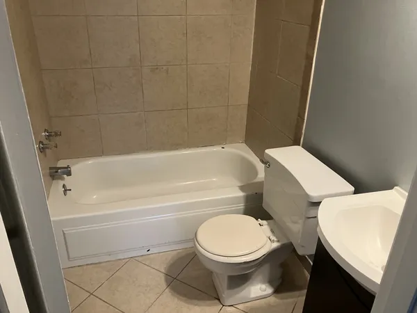 a white toilet and tub sitting next to a bathroom sink