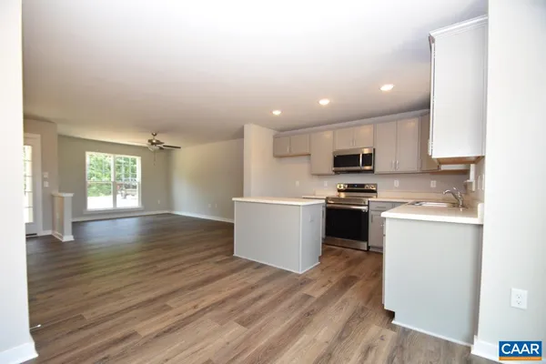 a kitchen with a white wooden floor stove top oven and cabinets