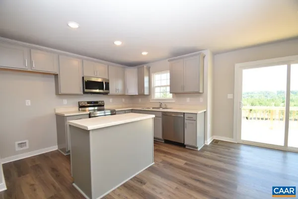 a kitchen with a sink a stove a microwave a center island and a window
