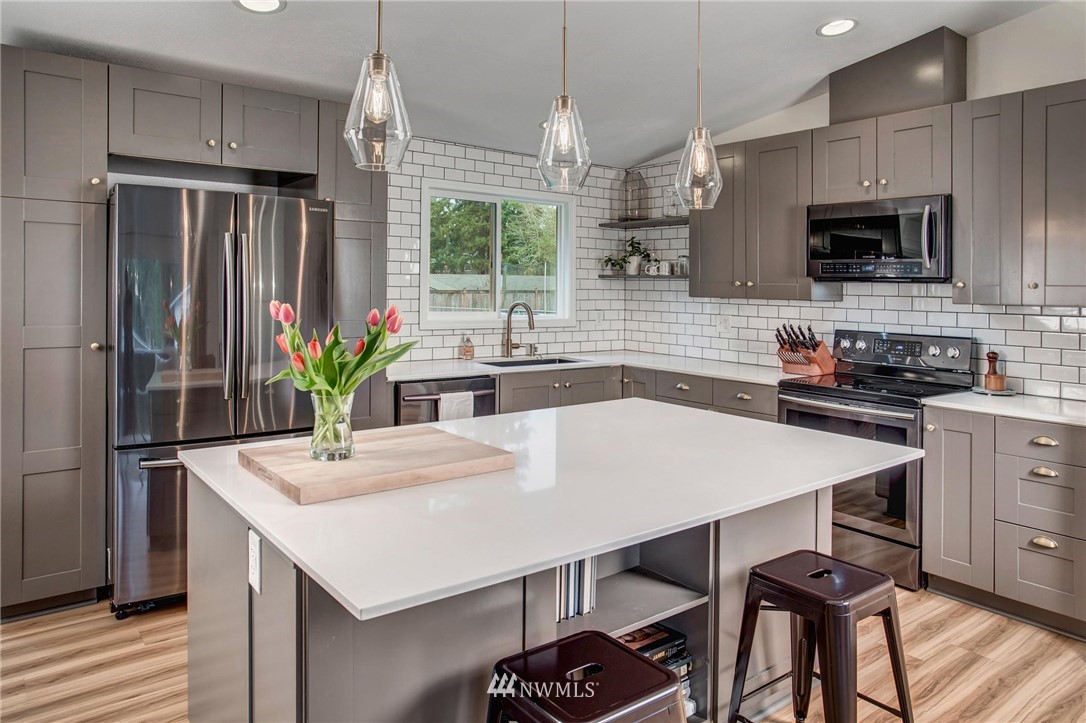 2321 177th Street Southeast Bothell, WA 98012 - Photo 12 of 28 a kitchen with stainless steel appliances a table chairs refrigerator and microwave