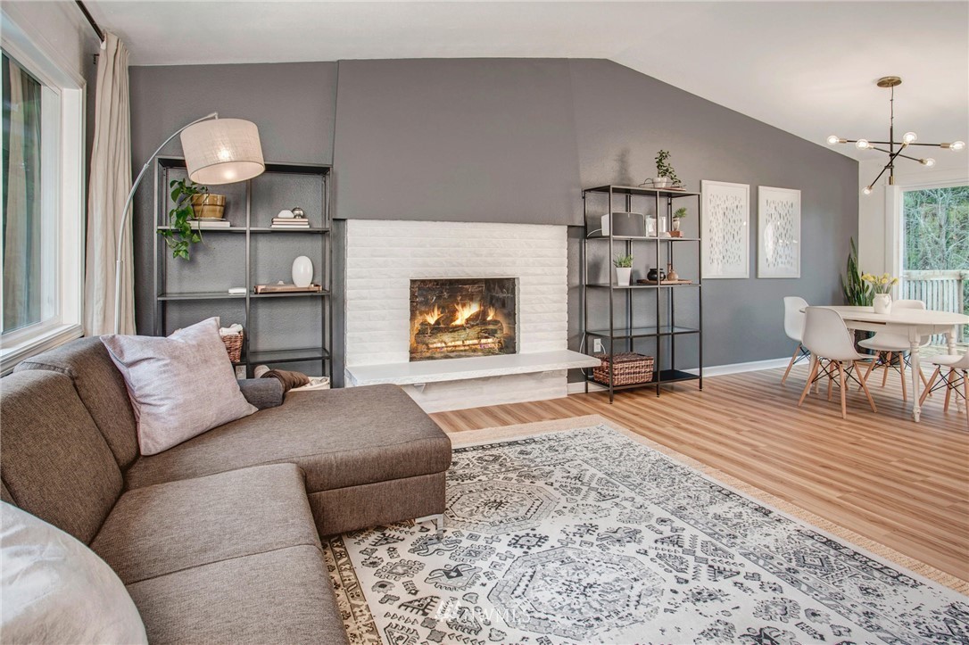 2321 177th Street Southeast Bothell, WA 98012 - Photo 9 of 28 a living room with furniture a fireplace and a dining table with wooden floor