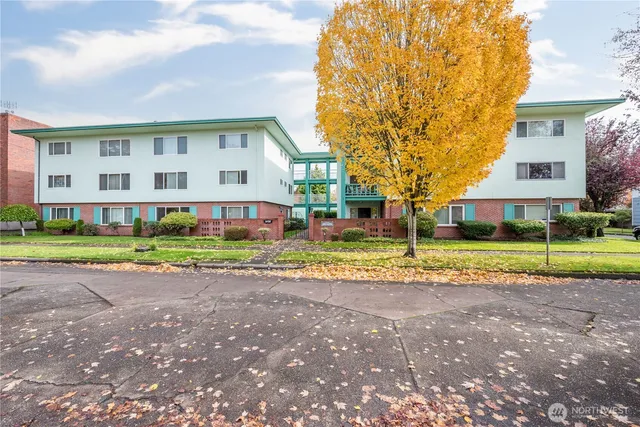 a view of a house with a big yard and large trees