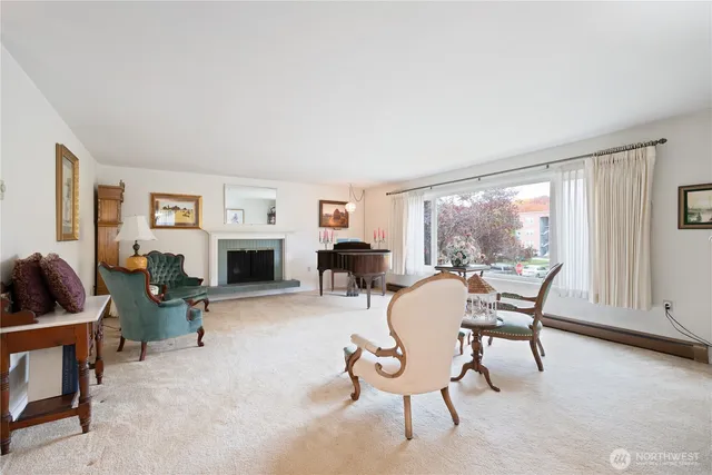 a living room with furniture a fireplace and a large window