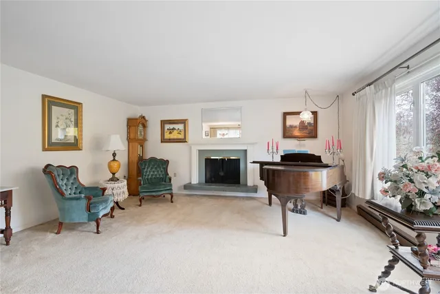 a living room with furniture a piano and a fireplace