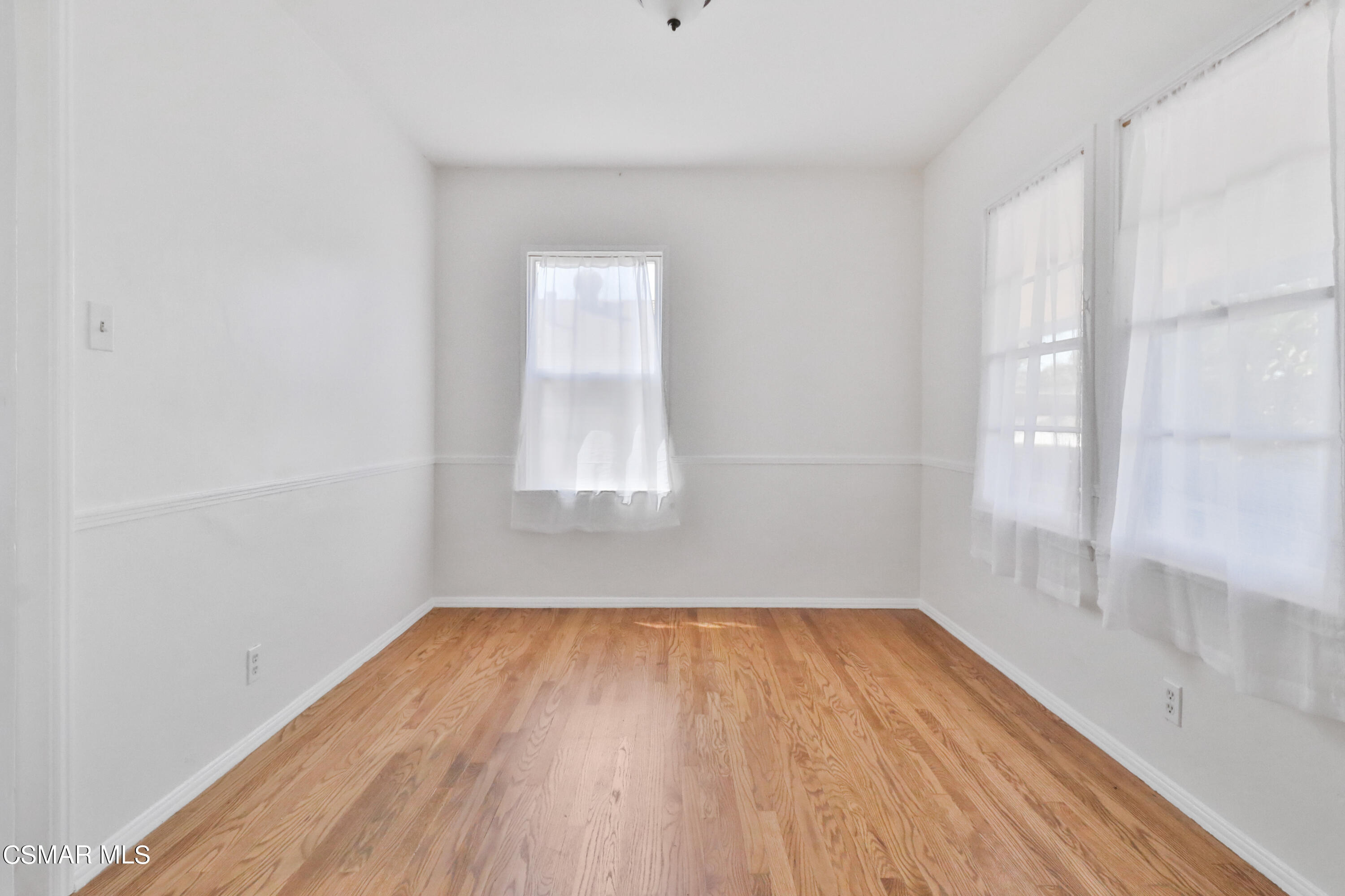 10010 Silverton Avenue Tujunga, CA 91042 - Photo 11 of 30 a view of a room with wooden floor and white walls