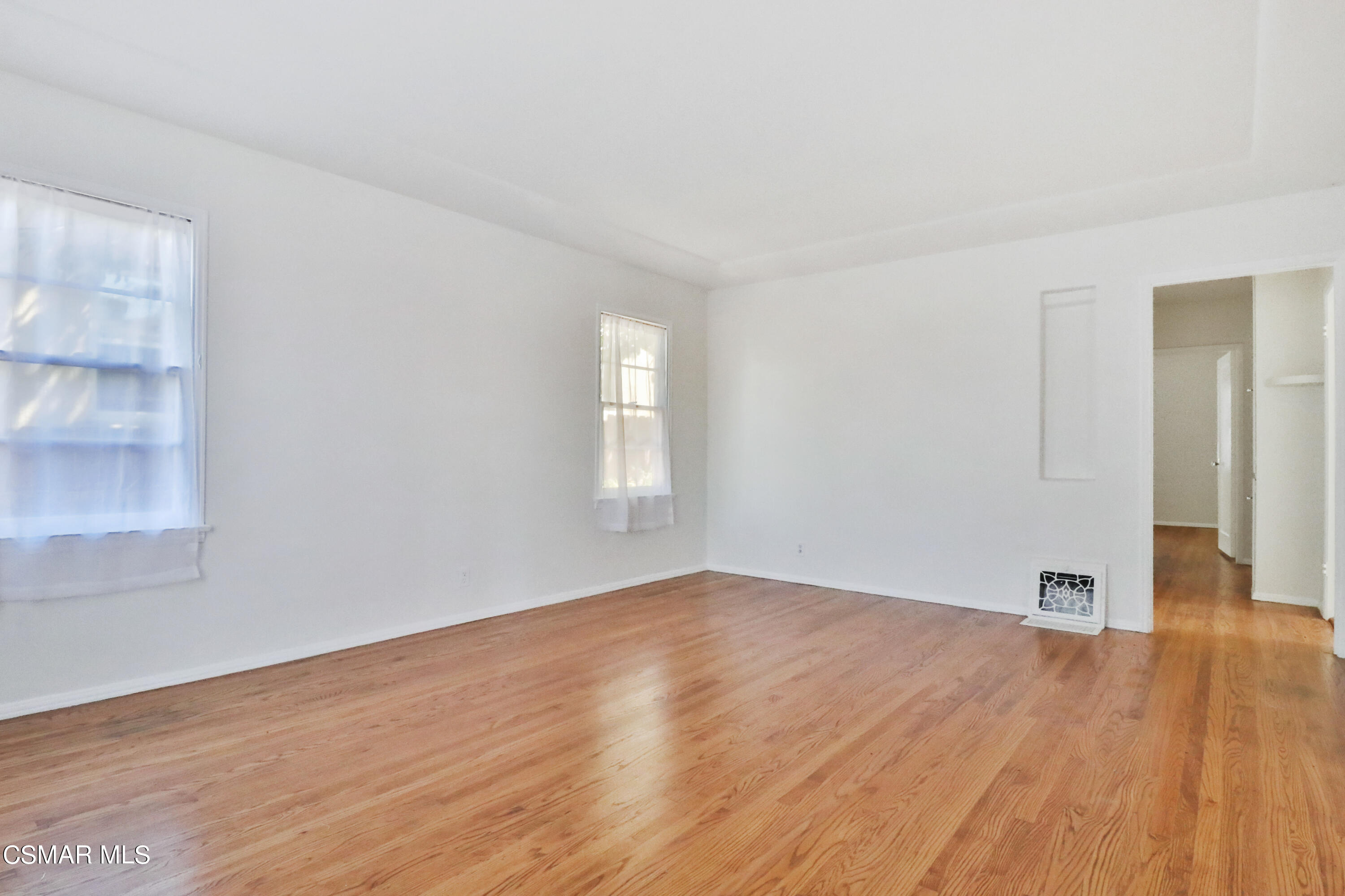 10010 Silverton Avenue Tujunga, CA 91042 - Photo 7 of 30 an empty room with wooden floor and windows