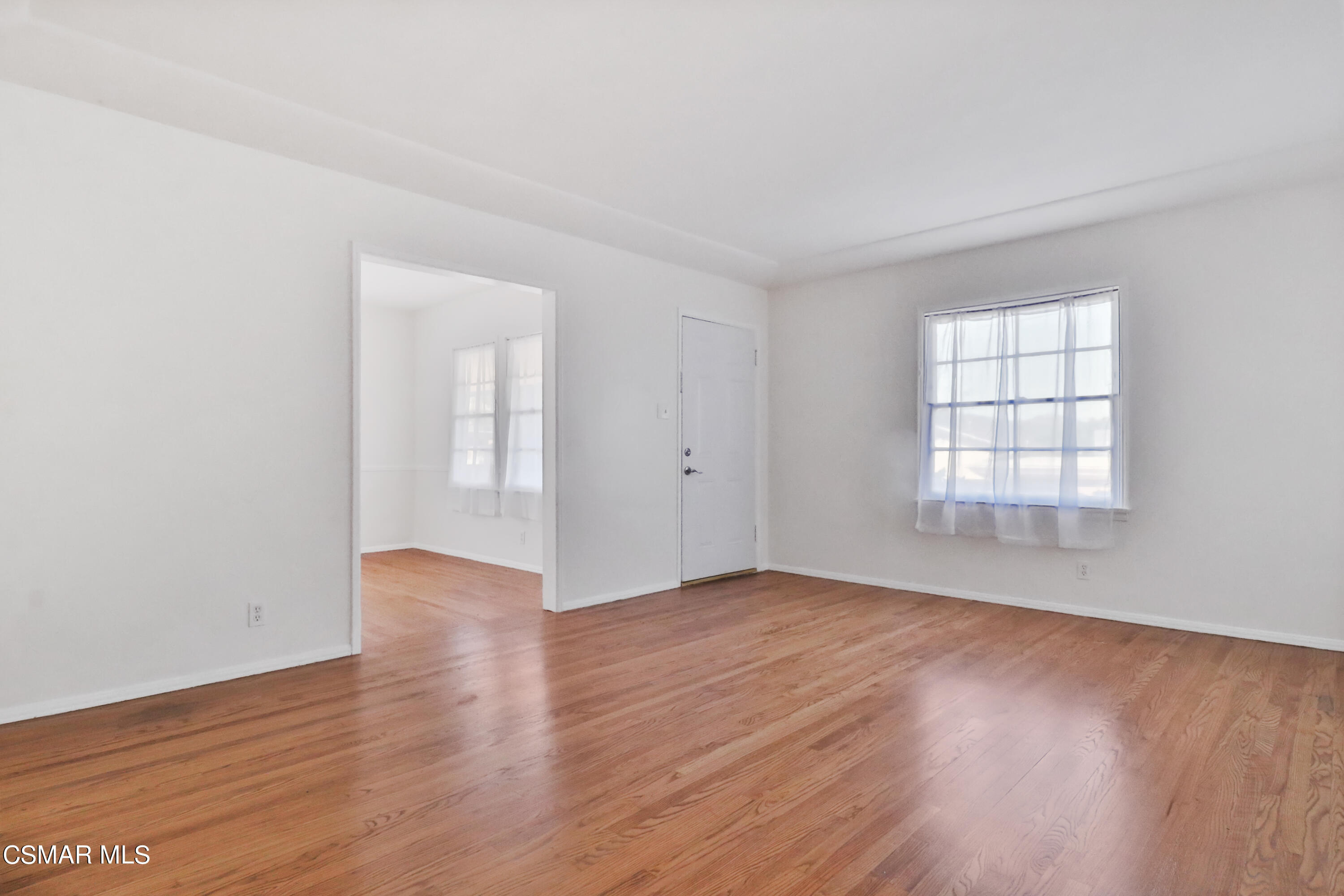 10010 Silverton Avenue Tujunga, CA 91042 - Photo 9 of 30 an empty room with wooden floor and windows