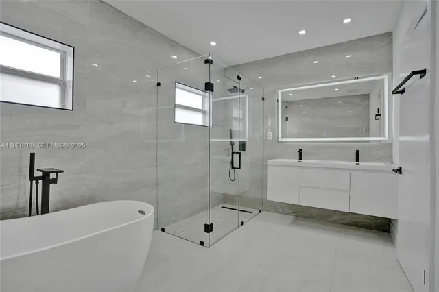 a bathroom with a tub a sink and mirror