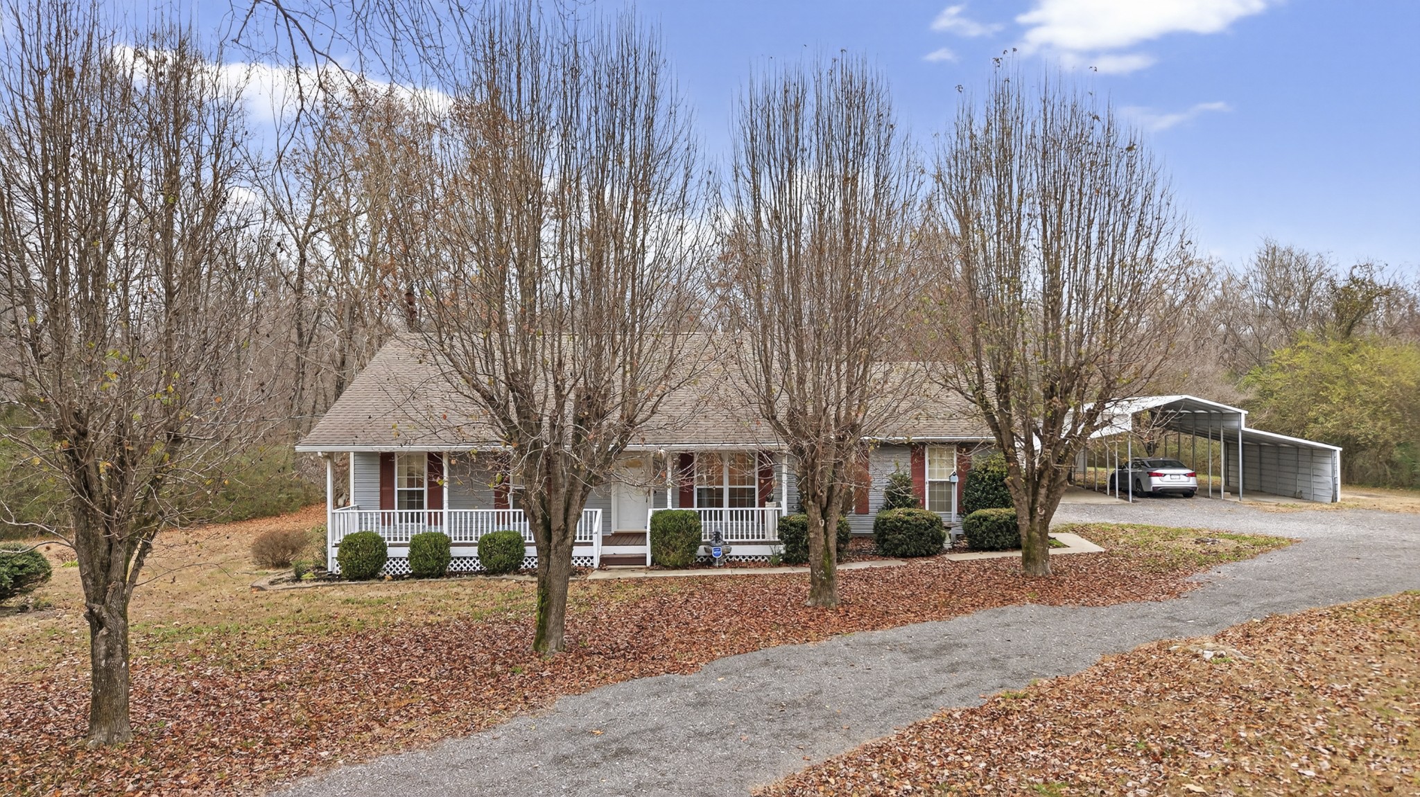a front view of a house with a yard and trees