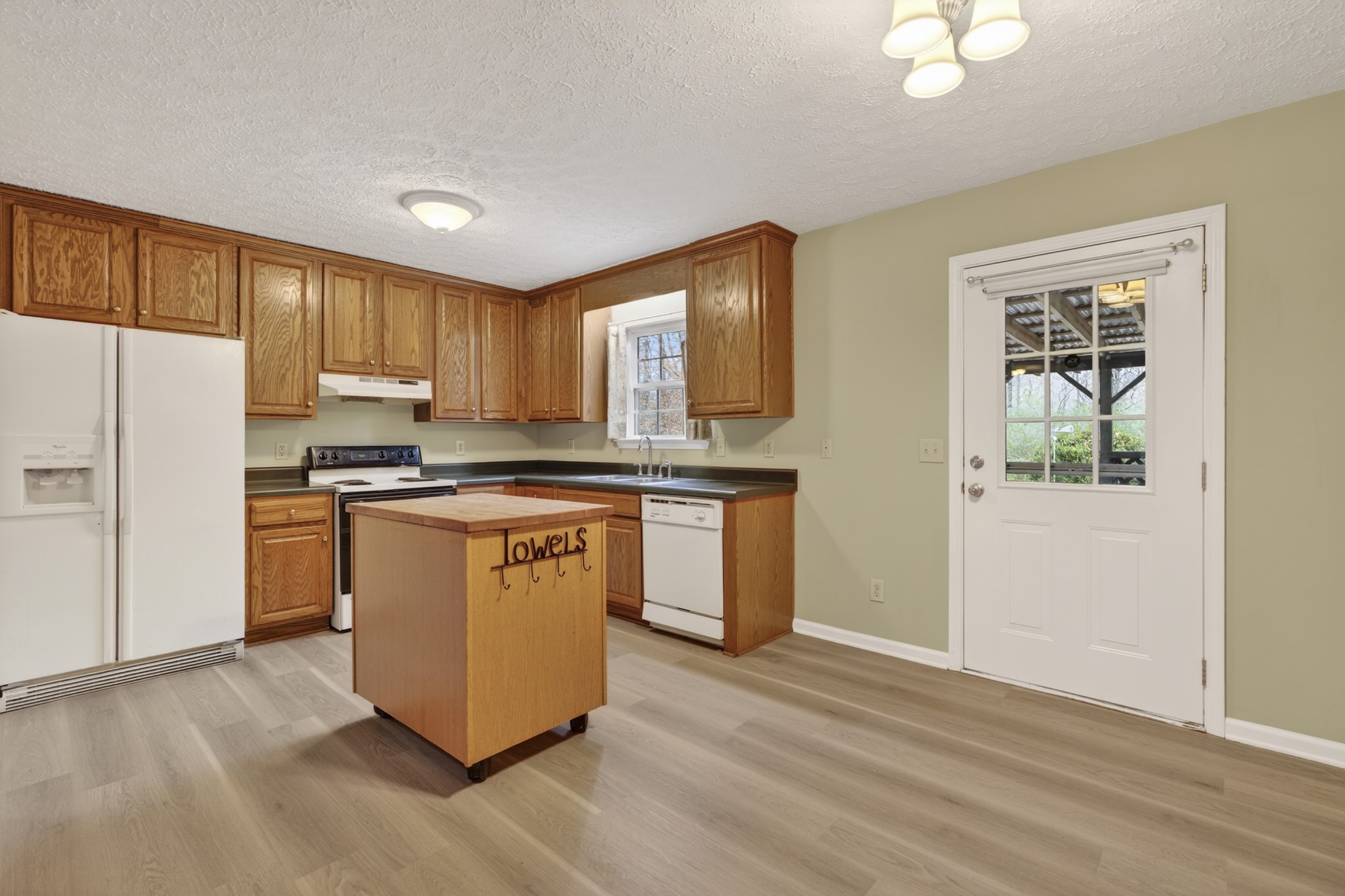 1041 Timber Ridge Road Charlotte, TN 37036 - Photo 14 of 20 a kitchen with stainless steel appliances granite countertop a stove a sink and a refrigerator with wooden floors