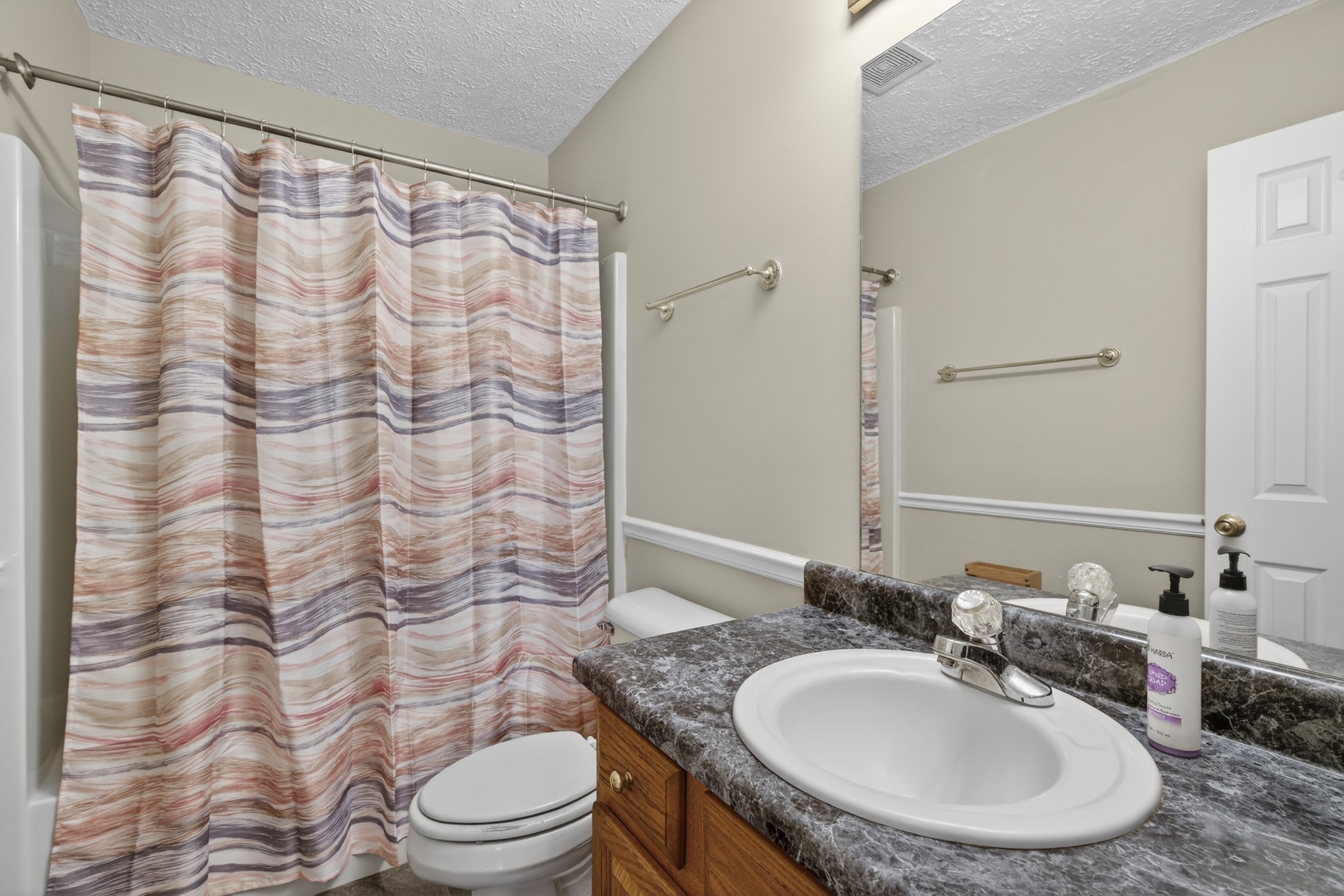 1041 Timber Ridge Road Charlotte, TN 37036 - Photo 16 of 20 a bathroom with a sink toilet a mirror and shower curtain