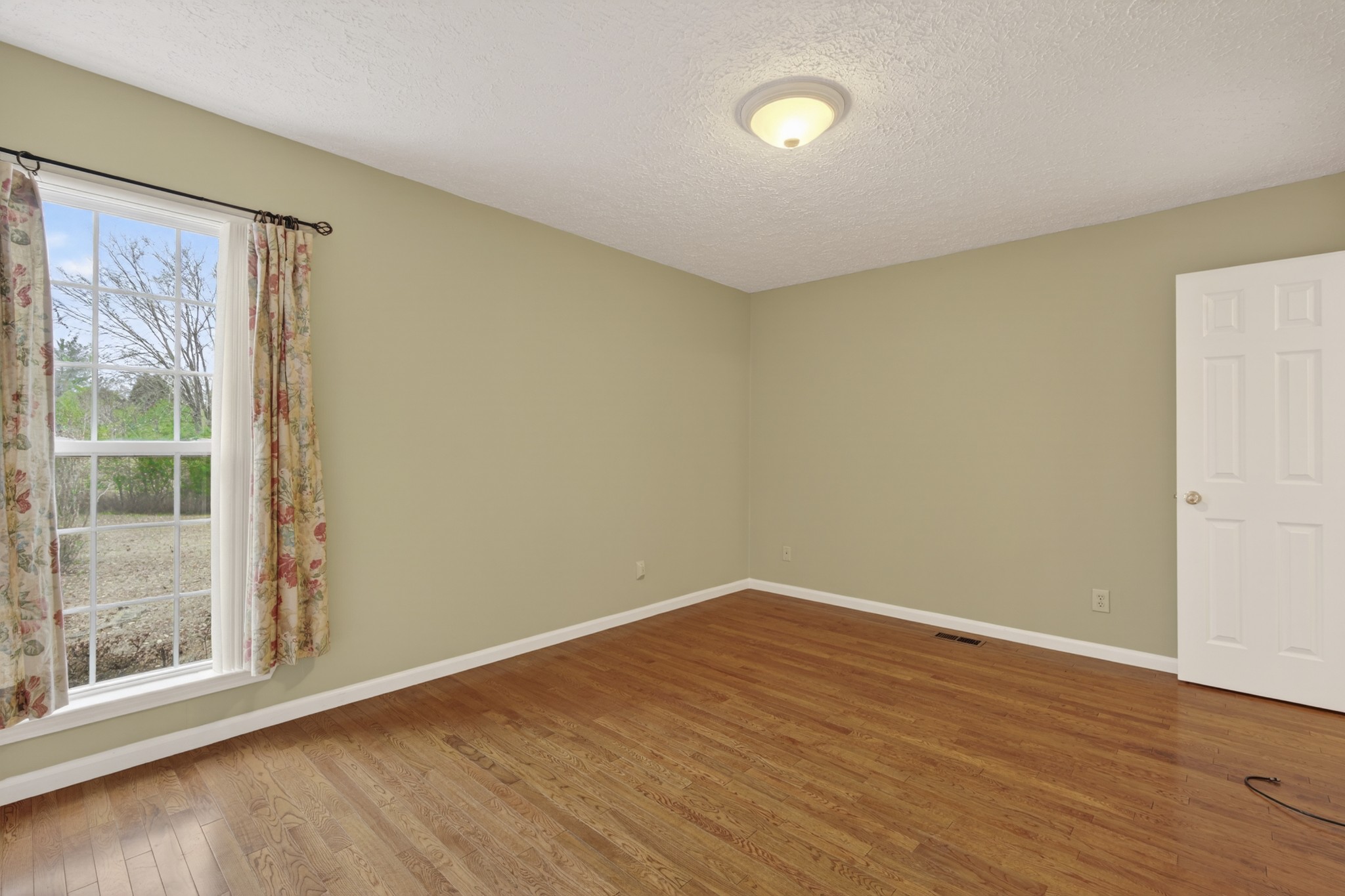 1041 Timber Ridge Road Charlotte, TN 37036 - Photo 18 of 20 a view of an empty room with wooden floor and a window