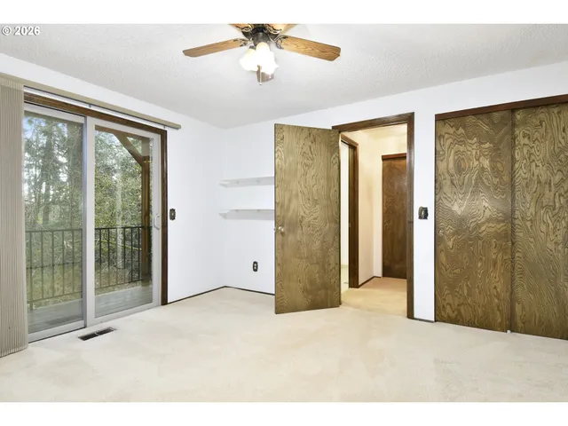 a view of an empty room with a chandelier fan