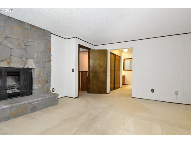 a view of an empty room with a fireplace