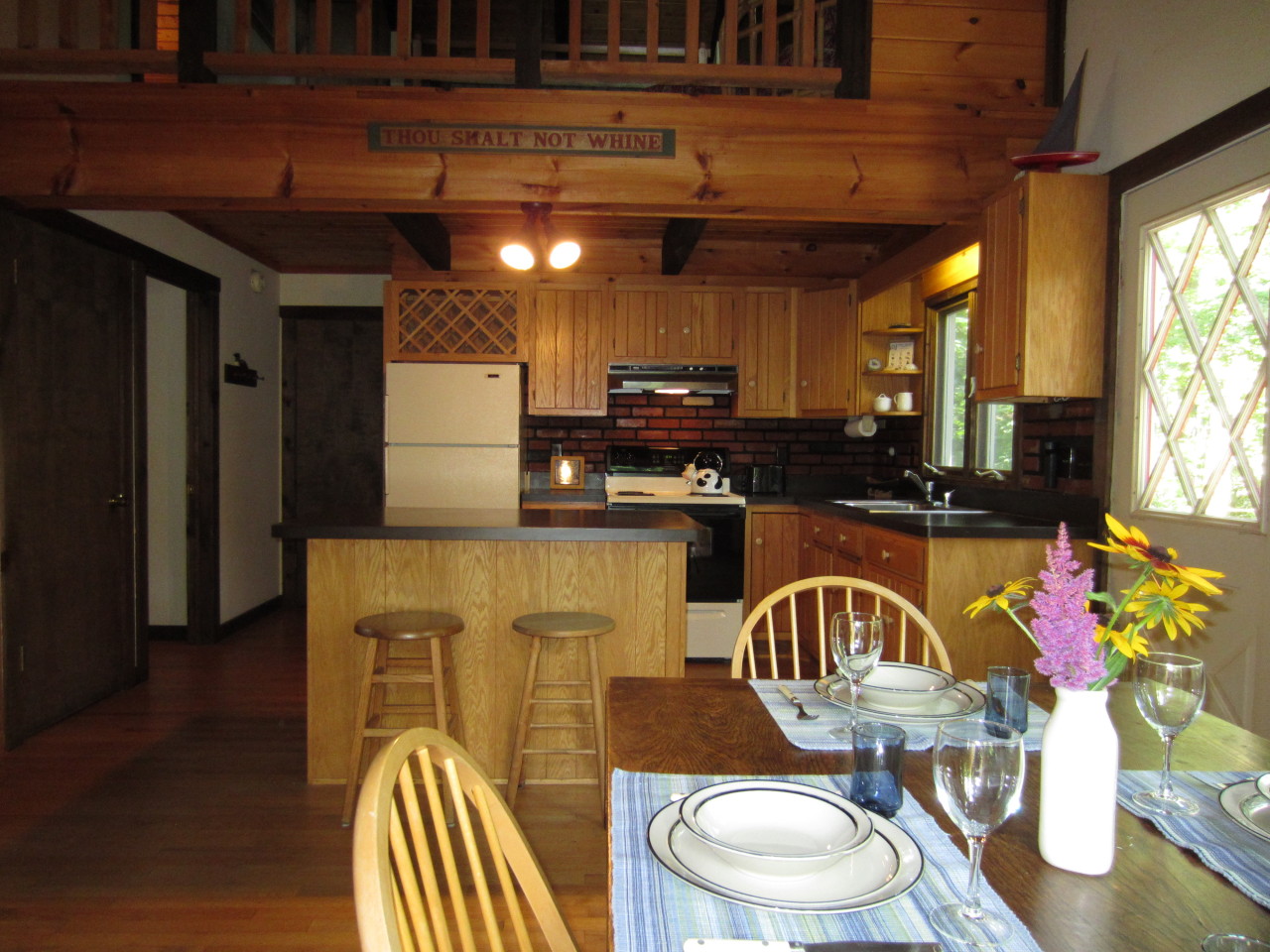 47 Slope Road Tolland, MA 01034 - Photo 9 of 19 a kitchen with stainless steel appliances granite countertop a stove a sink a refrigerator white cabinets wooden floor and a dining table