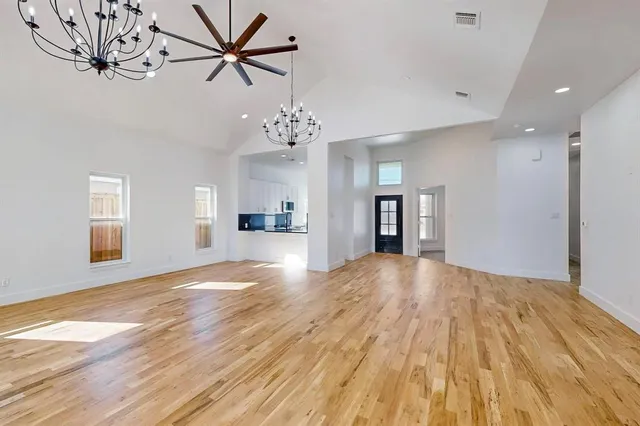 a view of empty room with wooden floor and window
