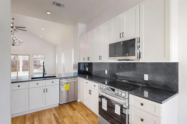 a kitchen with stainless steel appliances a sink a stove and cabinets