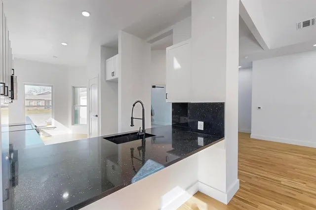 a large kitchen with stainless steel appliances a large counter top