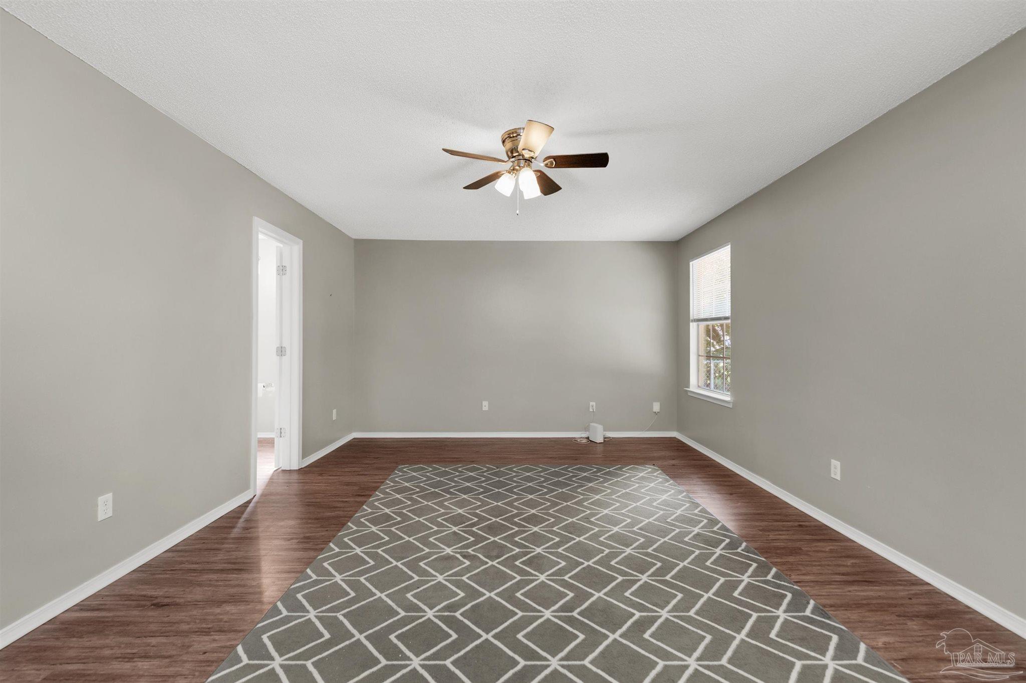 5499 Chantilly Circle Milton, FL 32583 - Photo 11 of 24 an empty room with windows and fan