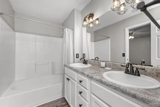 a bathroom with a granite countertop sink a large mirror and a bathtub
