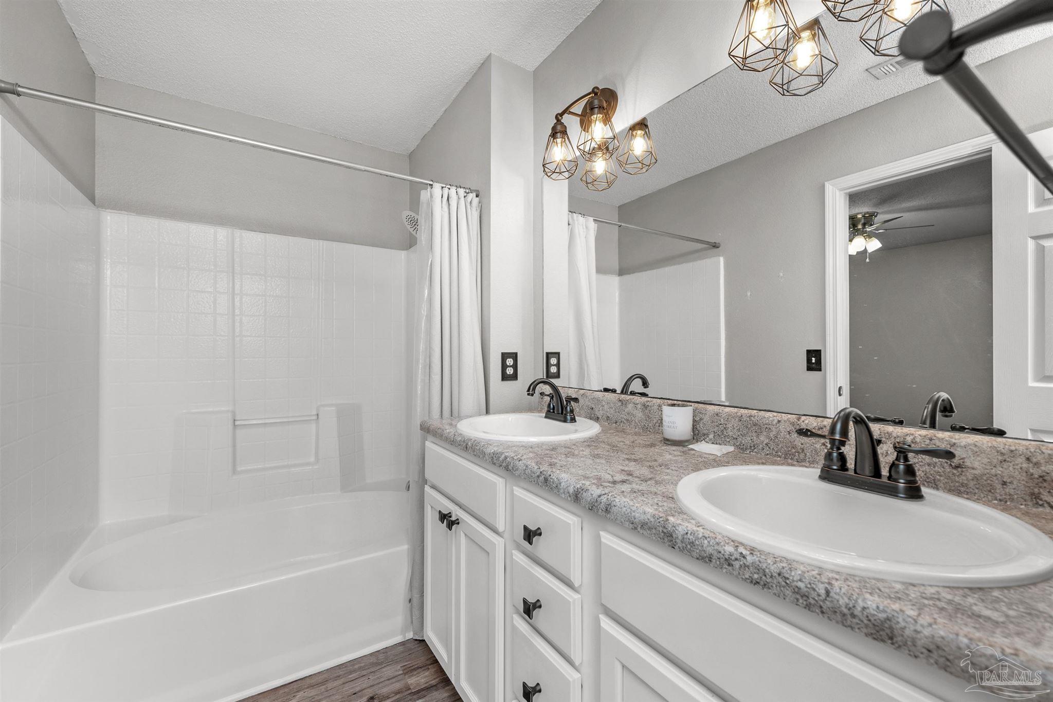 5499 Chantilly Circle Milton, FL 32583 - Photo 14 of 24 a bathroom with a granite countertop sink a large mirror and a bathtub