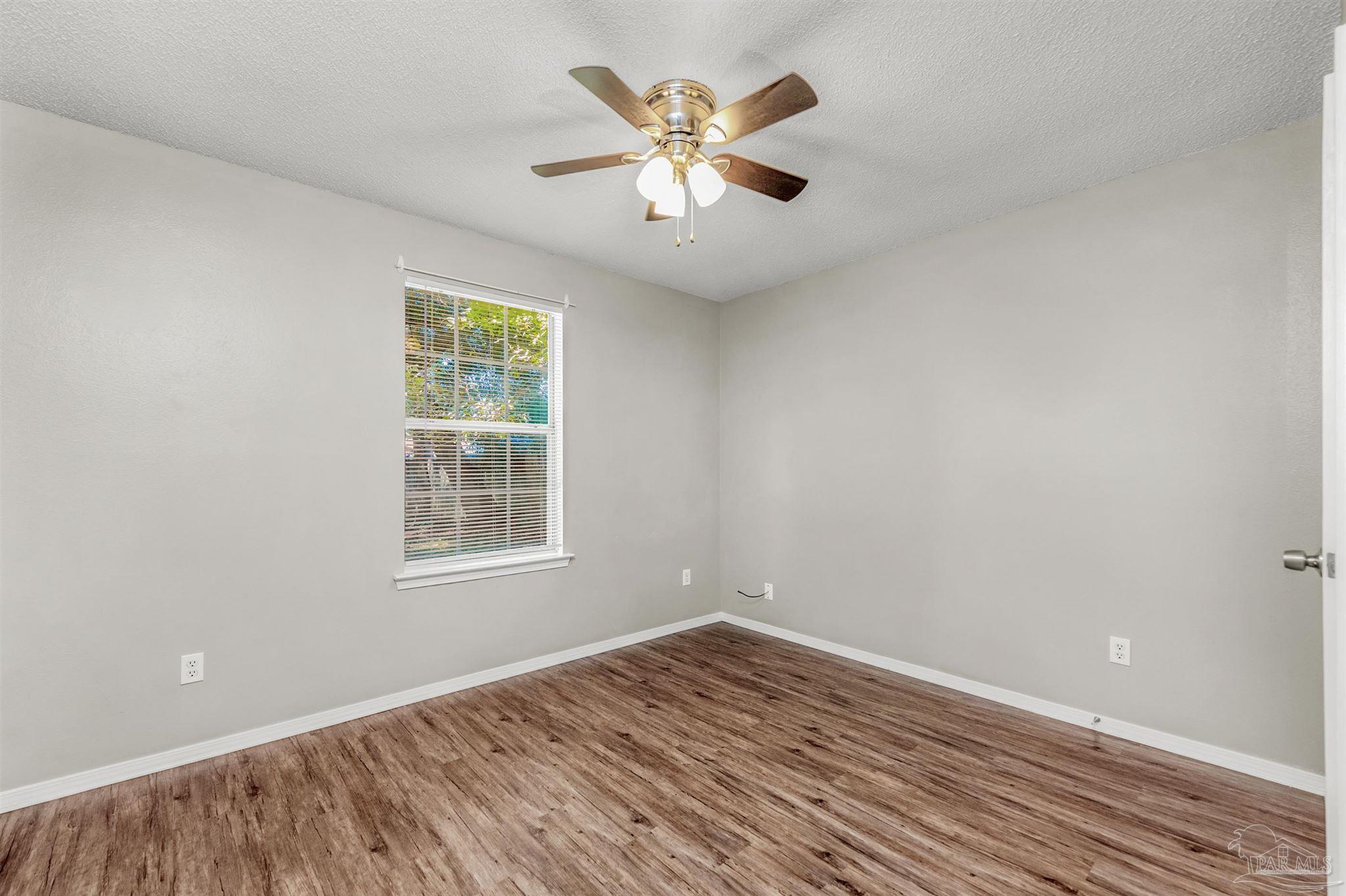 5499 Chantilly Circle Milton, FL 32583 - Photo 19 of 24 wooden floor in an empty room with a window