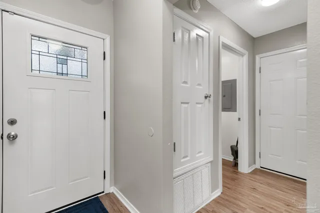 a view of a hallway with wooden floor and closet area