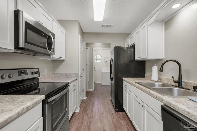 a kitchen with stainless steel appliances granite countertop a sink dishwasher stove and refrigerator