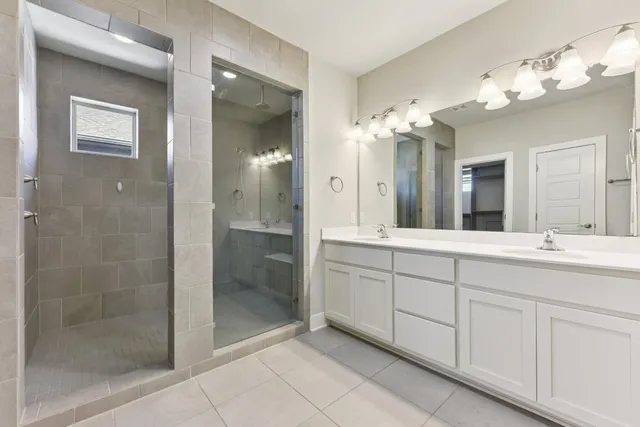 a spacious bathroom with a shower a sink and mirror