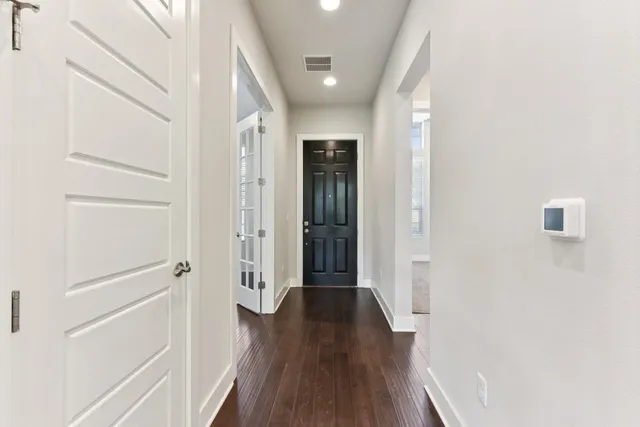 a view of a hallway with wooden floor and staircase
