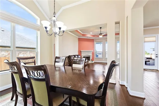 a view of a dining room with furniture a chandelier and wooden floor