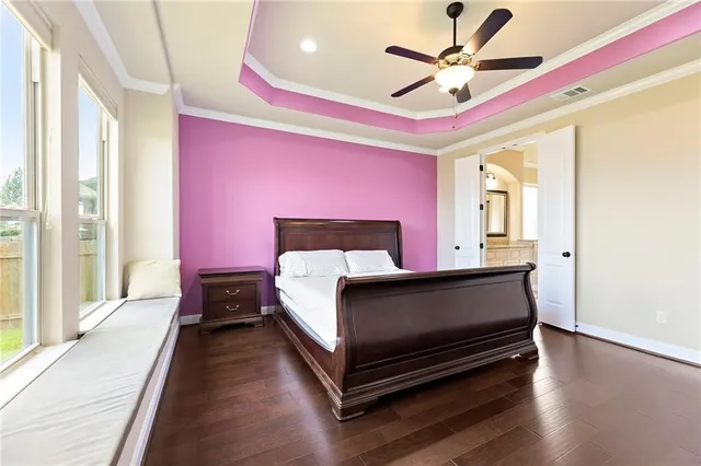 a spacious bedroom with a bed and a chandelier