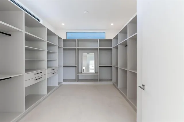 a view of walk in closet with empty racks